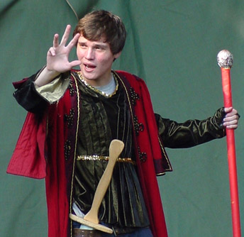 boy at acting camp, in costume with sword and staff, gesturing