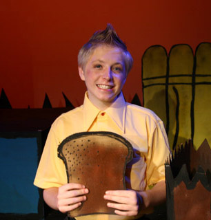 camper at musical theater camp playing Charlie Brown and holding giant toast