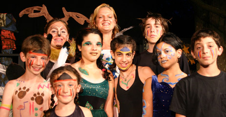 A theatre camp cast in fantasy makeup and costume with their director